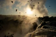 Sonnenuntergang über den Iguazú-Wasserfällen auf der Grenze von Brasilien zu Argentinien.