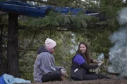 Bird Brown and Rain Brown sit around campfire to keep warm on Brown Ranch.