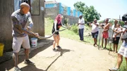 Simon Keys and Siouxsie Gillett find a Mozambique spitting cobra (Naja mossambica) in an old couch while cameraman James Boon captures the action.(National Geographic /Jed Kenny)