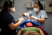 Dr. Lee and assistant work to remove Shoshana‚Äôs forehead lump.