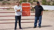 Tommy and Tory stand with warning sign.