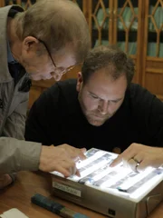 Josh Gates examines artifacts from the Dyatlov Pass Incident with historian Yuri Kuntsevich