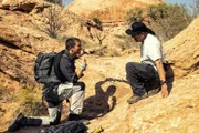 Bear Grylls shows Danny Trejo how to extract water. (National Geographic/Ben Simms)