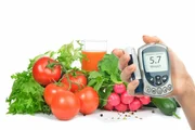 Diabetes concept glucose meter in hand and healthy organic food