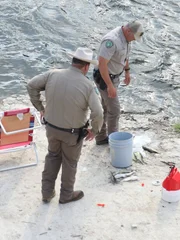 Game Wardens Justin Eddins and Morgan Inman checking on fish.