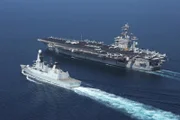 British Royal Navy destroyer HMS Diamond (D34) transits alongside aircraft carrier USS Dwight D. Eisenhower (CVN 69).