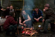 The Brown family boys sitting around a campfire.