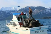 Matt goofing off on Lorcan, on top of tires.  Looks back at production boat.