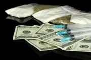 Drugs, money and syringes, isolated on black