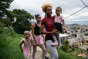 Tuany Nascimento, founder of "Na Ponta dos Pés" Ballet project, walks to class through Morro do Adeus, as she carries her student Aylla on her lap. Behind her from left to right we see: Anna Luiza, Raissa and Nelma. (MANDATORY photo credit: Sebastian Gil Miranda)