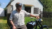 Josh Gates on his motorcycle in the Hungarian countryside.