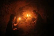 Josh Gates, Dr. Norbert Pap, and Erika Hancz search the dark recesses of a wine cellar.