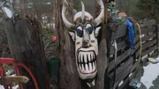 Wooden mask hung on a fence by the Brown family