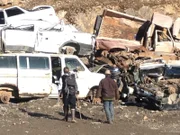 Noah Brown and Matthew Brown walking toward junk cars.