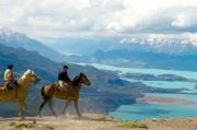 Das Bild zeigt zwei Gauchos, die auf die gewaltigen Weiten Patagoniens schauen. Sie sind auf der Suche nach Wildpferden, um sie zusammenzutreiben und zähmen. Patagonien ist eine der am schwersten zugänglichen Gegenden auf diesem Planeten und das Reisen auf dem Pferd ist immer noch essenziell für die Fortbewegung in dieser rauen Landschaft.