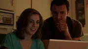 Vanessa and Ken sitting at a computer in the kitchen.