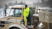 Casey morgan standing on the rock truck covered in snow