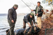 Hubert (Christian Tramitz, r.) und Staller (Helmfried von Lüttichau, M.) machen einen sehr viel größeren Fang als geplant. Statt eines Schwarzfischers (Roberto Martinez, l.) haben sie eine Leiche an der Angel ...