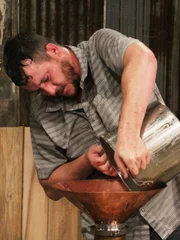 Travis pouring mash in his still