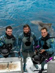 Mark Romanov, Forrest Galante and John Harrington III on the edge of the boat in their HECS suits.