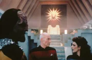 Captain Picard (Patrick Stewart, M.), Lt. Worf (Michael Dorn, l.) und Deanna Troi (Marina Sirtis, r.) befinden sich in einem Teil der Enterprise, der in einen Tempel verwandelt wurde.