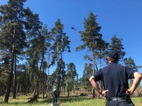 Ein Helikopter mit dem sogenannten Bambi-Bucket, einem Wassertransportbehälter, im Anflug zum Testabwurf. Christoph Lamers vom Institut der Feuerwehr in NRW beobachtet die Übung aus sicherer Entfernung. Ein Helikopter mit dem sogenannten Bambi-Bucket, einem Wassertransportbehälter, im Anflug zum Testabwurf. Christoph Lamers vom Institut der Feuerwehr in NRW beobachtet die Übung aus sicherer Entfernung.