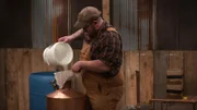 Gian pouring moonshine into bucket.