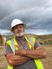 Hero shot of Jesse Goins. Arms crossed with a rainbow in the background