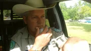 Mike Boone speaks on intercom in police car.