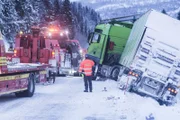 Overhalla, Norway - An accident in Overhalla. We can see the back of Roger Heggeli (one of the cast in Overhalla). A truck is stuck in the ditch and two towing trucks are helping it and has two wires attached in the back of the truck.   (National Geographic)