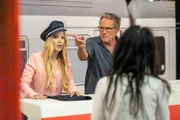 Andrea Kaiser und Christian Tramitz stehen hinter einem Bahnschalter im Studio.