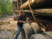 Joy secures her load of wood with tie down straps.