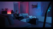 Woman plays video game from couch in room with nice lighting.