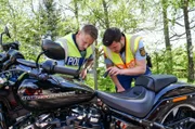 Die beiden Polizeioberkommissare Mike Büchel und Florian Becker untersuchen ein Motorrad nach illegalen Umbauten und Mängeln.