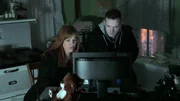 Amy Bruni and Adam Berry looking at a monitor during a nighttime investigation at the Villisca Ax House in Villisca, IA.
