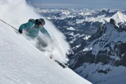 Free ride skier turns in powder snow.