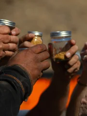 Close up - Everyone raises their jars of gold in tribute to & memory of Comrade/Husband Jesse Goins