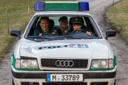 Johann Eberle (Joost Siedhoff, M.) wird von Hubert (Christian Tramitz, l.) und Staller (Helmfried von Lüttichau, r.) im Polizeiauto aufs Revier gefahren.