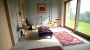 Das Musikzimmer mit unverputzem Backsteinmauerwerk im nachhaltigen Erdhaus.