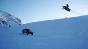 Ein Schneemobil fährt um die Wette mit VWs Rally Touareg.