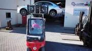 A mechanic carries a car with a forklift truck.