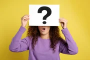 woman with question mark sign on yellow