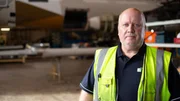 contributor in Hangar with plane in background