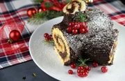 Buche di Noel. Christmas yule log cake on dark background. Traditional Christmas dessert.