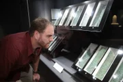 Josh Gates examining the Copper Scroll in the Jordan Museum.