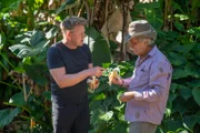 Hawaii - Farmer, Chuck Boerner (R), shares sweet, red bananas with Gordon Ramsay.