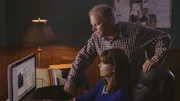 Lynne Banks and her husband looks at a computer screen.
