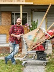 Keith Bynum standing outside of Cherrylawn home with their shopping cart