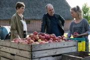 Jette Lorenzen (Gundula Niemeyer, l.) und Oskar Schütz (Marek Erhardt, M.) befragen die Erntehelferin Raluka Radu (Barbara Prakopenka, r.) nach ihrem Verhältnis zu dem Toten.