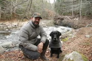 Jason and his dog Moses pose near a river. (National Geographic)